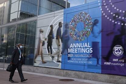 A man with face mask walks past the International Monetary Fund headquarters in Washington, D.C., the United States, Oct. 14, 2021